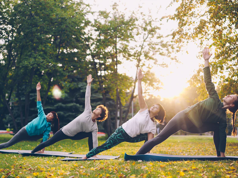Cours de yoga en plein air au soleil couchant